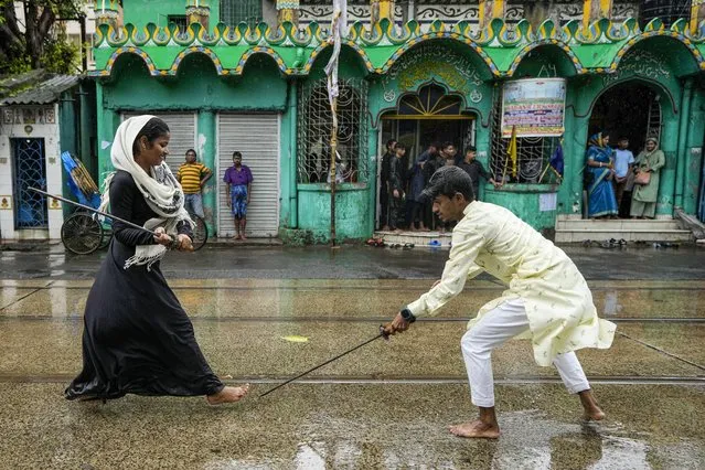 A Muslim girl participates in a mock fight during a Muharram procession in remembrance of the martyrdom of Imam Hussein, the grandson of the prophet Mohammad in Kolkata, India on August 9, 2022. (Photo by Bikas Das/AP Photo)