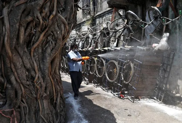A municipal worker disinfects parked rickshaws in an alley during a 21-day nationwide lockdown to limit the spreading of the coronavirus disease (COVID-19), in Kolkata, India, March 30, 2020. (Photo by Rupak De Chowdhuri/Reuters)