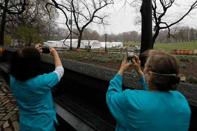 Nurses from Mount Sinai Hospital take pictures of field tents being erected as a makeshift hospital in the East Meadow of Central Park by the disaster relief organization Samaritan's Purse in New York, New York, USA, 29 March 2020. New York City is now an epicenter of coronavirus COVID-19, the disease caused by the virus, New York has reported over 59,000 confirmed cases and over 965 deaths. (Photo by Peter Foley/EPA/EFE)