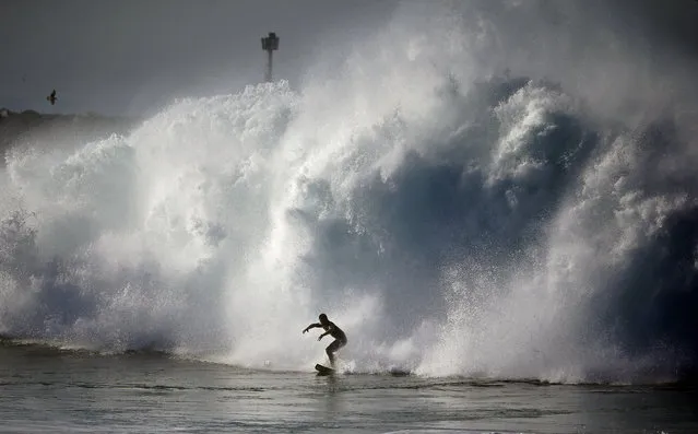 A surfer rides a wave at the wedge in Newport Beach, Calif., Wednesday, August 27, 2014. (Photo by Chris Carlson/AP Photo)