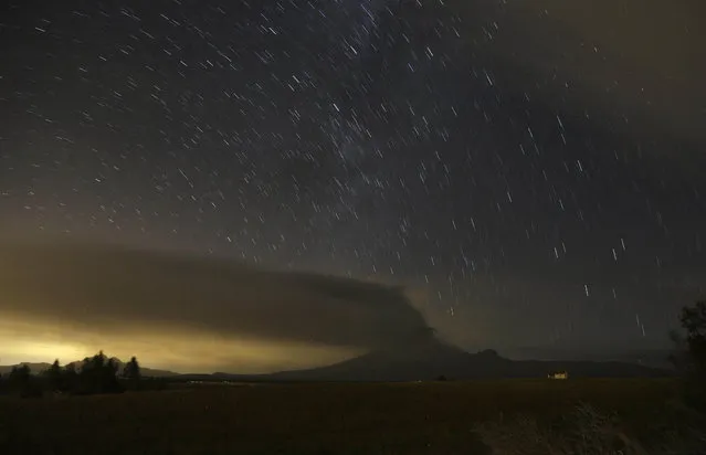 In this time exposure photo, the Cotopaxi volcano spews ash and vapor, as seen from Alaquez, Ecuador, Thursday, Sept. 3, 2015. Cotopaxi began showing renewed activity in April and its last major eruption was in 1877. (Photo by Dolores Ochoa/AP Photo)