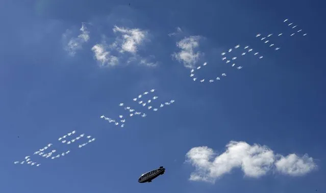 A blimp flies near skywriting during singles matches at the Ryder Cup in Medinah, Illinois, on September 30, 2012. Europe started the day trailing 10-6, a deficit overcome only once before in he history of the competition. (Photo by Charlie Riedel/Associated Press)