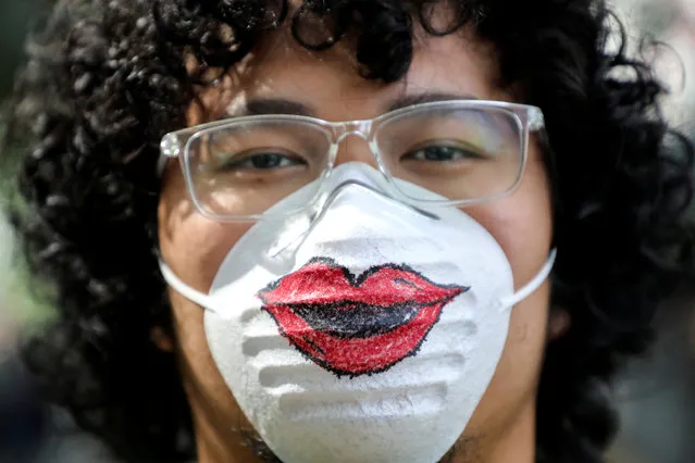 A man wearing a protective mask that features a pair of lips poses for a picture during a Women's March to mark International Women's Day in Kuala Lumpur, Malaysia, March 8, 2020. (Photo by Lim Huey Teng/Reuters)
