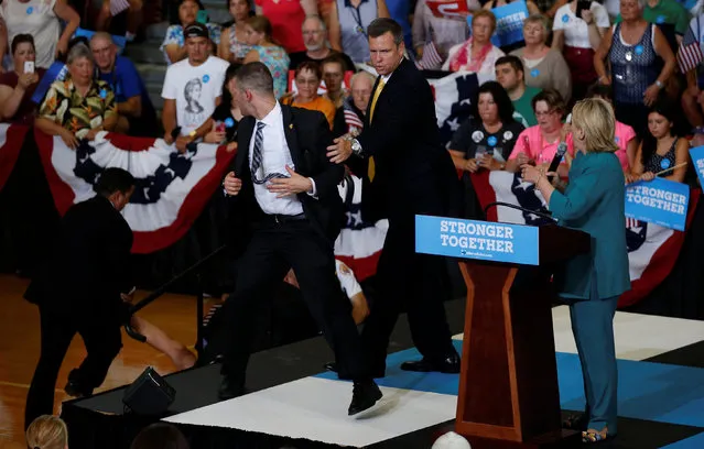 Secret Service officers work to secure U.S. Democratic presidential nominee Hillary Clinton after a protestor jumped into the buffer during a rally at Lincoln High School in Des Moines, Iowa August 10, 2016. (Photo by Chris Keane/Reuters)