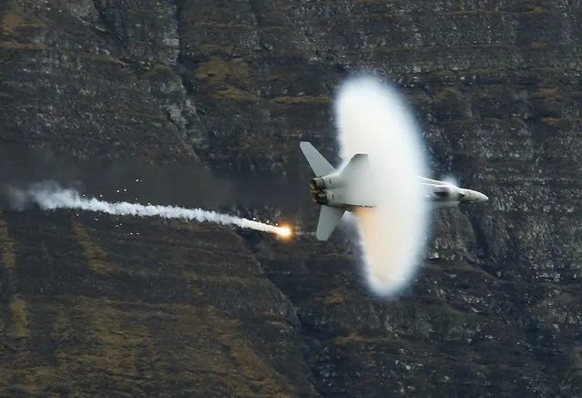 A Swiss Air Force F18 fighter jet releases flares during a flight demonstration of the Swiss Air Force over the Axalp in the Bernese Oberland October 11, 2012. (Photo by Pascal Lauener/Reuters photo)