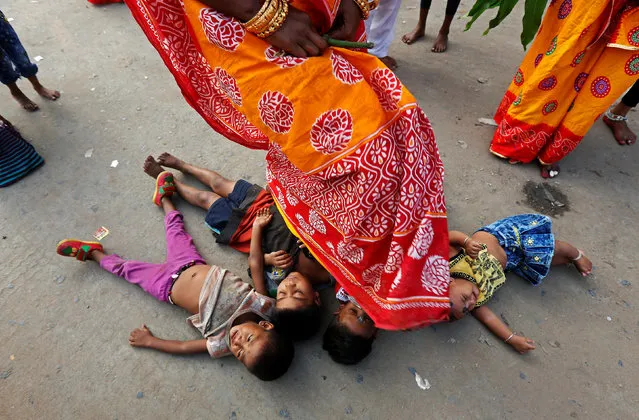 A Hindu woman steps over children in a ritual seeking blessings for the children from the Sun god during the religious festival of Chhath Puja in Kolkata, India October 26, 2017. (Photo by Rupak De Chowdhuri/Reuters)