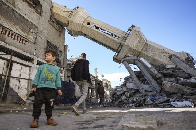 Palestinians walk past a mosque destroyed by Israeli airstrikes in Nuseirat, Gaza Strip, Friday, January 24, 2025, days after a ceasefire deal between Israel and Hamas came into effect. (Photo by Abdel Kareem Hana/AP Photo)