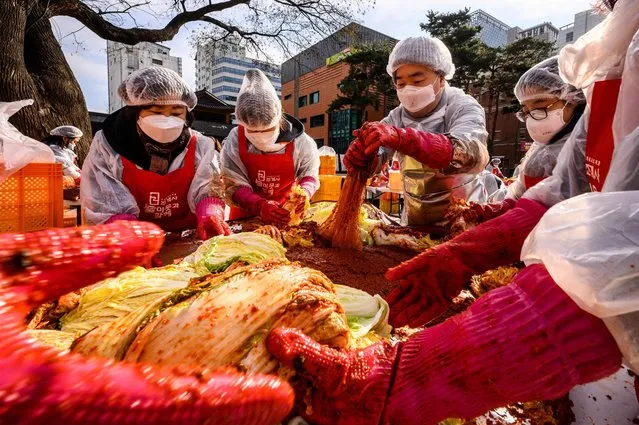 Participants prepare kimchi, a traditional Korean dish of spicy fermented cabbage and radish, during a kimchi making festival at the Jogyesa Buddhist temple in Seoul on December 2, 2021, before it is distributed among the less privileged from the local neighbourhood. (Photo by Anthony Wallace/AFP Photo)
