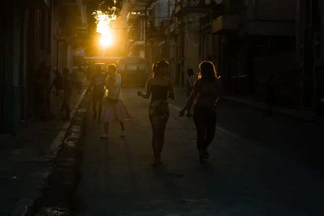 Cubans are pictured walking on the street in Central Havana as the sun sets behind them. As the long Castro era is coming to a close, Cuba is once more grappling with the question of what, exactly, was the purpose of the revolution. (Photo by Sarah L. Voisin/The Washington Post)