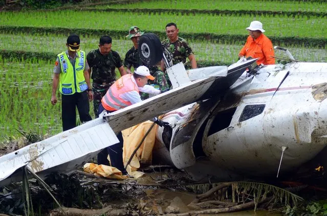 Indonesian officers from the National Transportation Safety Committee (KNKT) investigate a crashed Piper Warrior trainer plane on a paddy field in Tasikmalaya, West Java, Indonesia, 19 August 2016. According to media reports, the trainer plane crashed into the paddy field on 18 August, three people on board were injured in the crash. (Photo by EPA/Daenk)