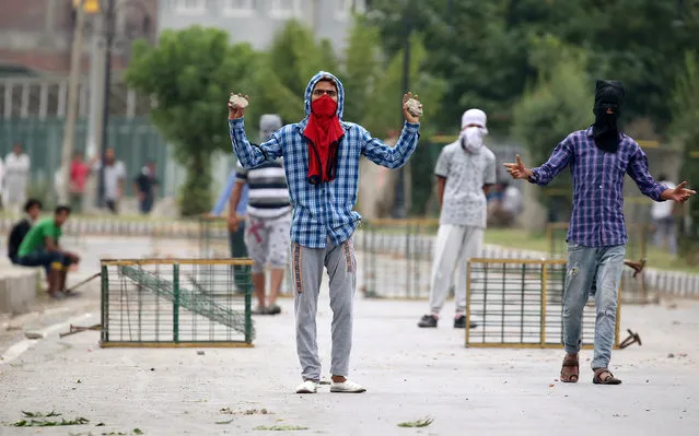 Men gesture at security personnel following the death of Irfan Ahmed, who according to local media died after being hit by a tear gas canister fired by security forces, in Srinagar, August 22, 2016. (Photo by Cathal McNaughton/Reuters)