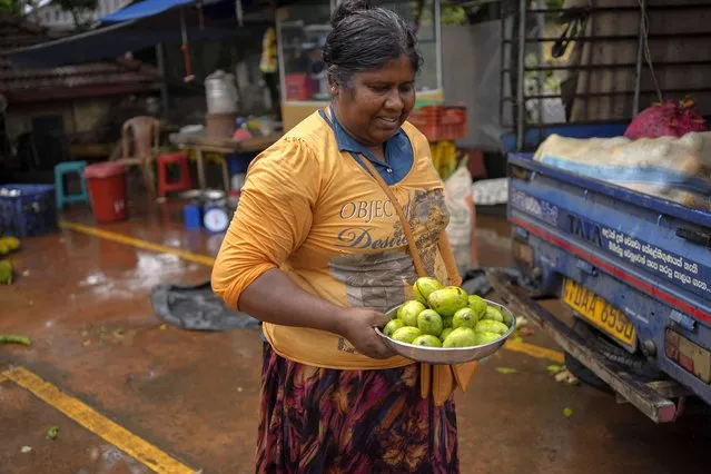 A woman sells mangos at a market place in Colombo, Sri Lanka, Friday, October 21, 2022. (Photo by Eranga Jayawardena/AP Photo)