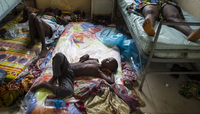 A boy lays on a mattress on the floor inside the Redemption  Hospital which has become a transfer and holding center to intake Ebola patients located in one of the poorest neighborhoods of Monrovia that locals call “New Kru Town” on Saturday September 20, 2014 in Monrovia, Liberia. Health workers are overwhelm with a constant stream of  new patients since the Ebola outbreak. (Photo by Michel du Cille/The Washington Post)