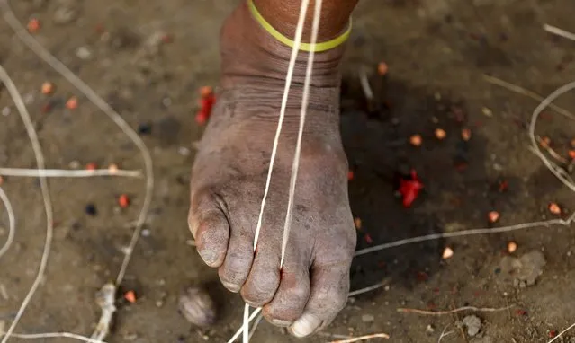 A Colombian Nukak Maku Indian man weaves with his foot in a refugee camp at Agua Bonita near San Jose del Guaviare of Guaviare province September 3, 2015. (Photo by John Vizcaino/Reuters)
