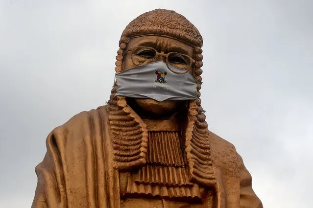 The statue of late lawyer and rights activist Gani Fawehinmi wears a face mask at the Liberty Park at Ojota in Lagos, Nigeria on July 27, 2020. The 34-feet statue to immortalise the fiery lawyer and rights advocate is being used to sensitise people to the sanitary measures taken to curb the spread of the COVID-19 pandemic in Lagos, Nigeria's commercial hub and epicentre of the virus in the country. (Photo by Pius Utomi Ekpei/AFP Photo)