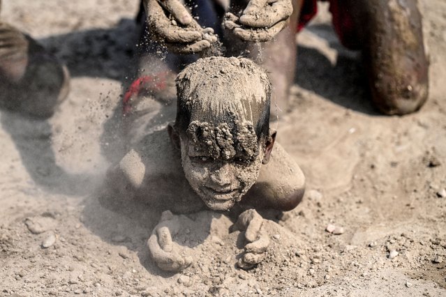Young boys apply mud to cool themselves near a makeshift pool along the banks of the Yamuna River on a hot summer day in New Delhi on April 8, 2025. (Photo by Sajjad Hussain/AFP Photo)