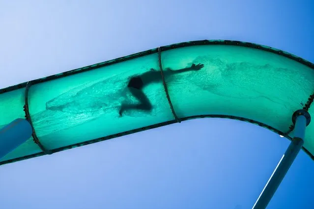 A human figure silhouetted in a waterslide in Adelaide, Australia on November 24, 2022 as people take advantage of the warm sunshine with temperatures forecast to climb to 31celsius in Adelaide. (Photo by Amer Ghazzal/Alamy Live News)
