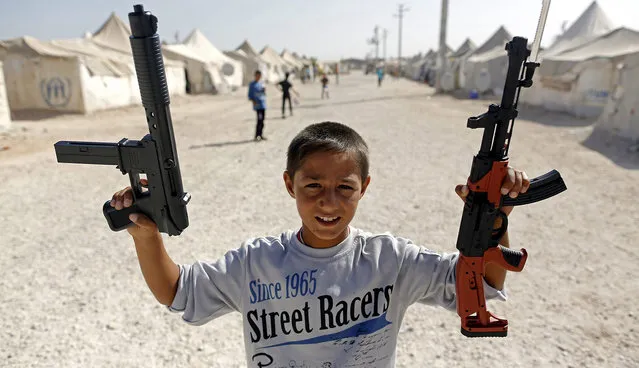 A Syrian refugee boy plays with toy guns at Akcakale Refugee Camp in Sanliurfa, southeastern Turkey, 24 September 2015. (Photo by Cem Turkel/EPA)