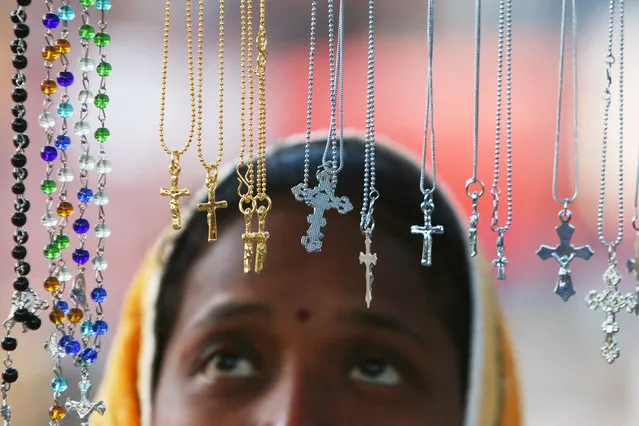 A woman looks at religious lockets at a stall outside a church during the Christmas celebrations in Chandigarh, India, December 25, 2017. (Photo by Ajay Verma/Reuters)