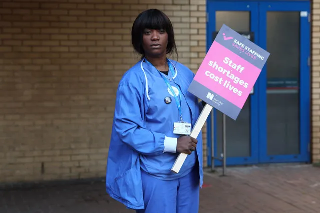 A healthcare worker holds a placard at a picket line outside St Mary's Hospital in west London on December 15, 2022. UK nurses staged an unprecedented one-day strike as a “last resort” in their fight for better wages and working conditions, despite warnings it could put patients at risk. (Photo by Isabel Infantes/AFP Photo)