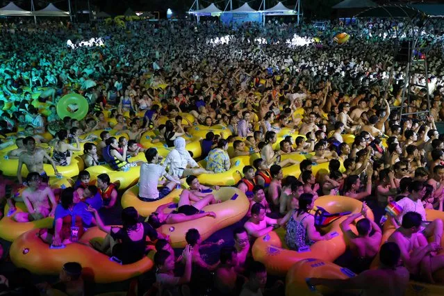 People enjoy a music party inside a swimming pool at the Wuhan Maya Beach Park following the coronavirus outbreak in Wuhan, Hubei province, China on August 15, 2020. (Photo by Reuters/China Stringer Network)