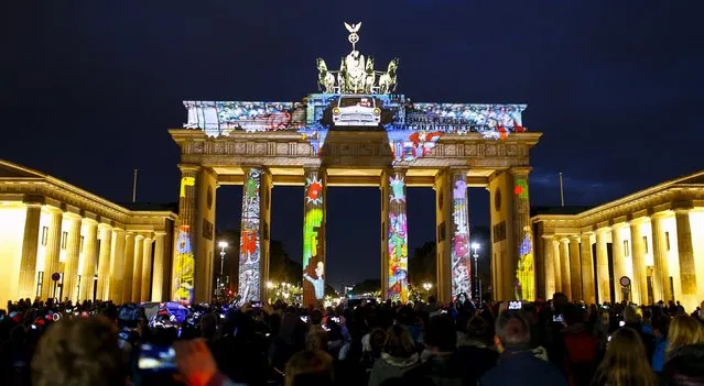 People look at a light installation at the Brandenburg Gate during the opening day of the "Festival of Light" show in Berlin, Germany, October 9, 2015. (Photo by Hannibal Hanschke/Reuters)