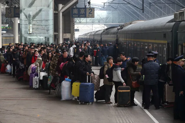 People wait in line to board a train at Nanjing railway station as the travel rush for Chinese Lunar New Year, or Spring festival, begins, in Jiangsu province, China on February 1, 2018. (Photo by Reuters/China Daily)