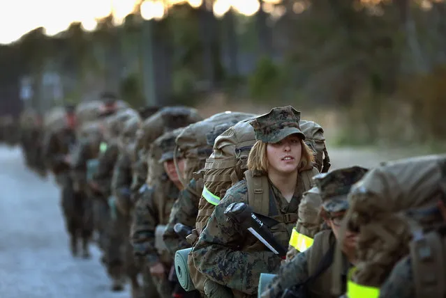 Pfc. Schevlle Woodard from Grand Prairie, Texas prepares to head out on a 15-kilometer night march with male and female Marines during Marine Combat Training (MCT) on February 21, 2013 at Camp Lejeune, North Carolina.  Since 1988 all non-infantry enlisted male Marines have been required to complete 29 days of basic combat skills training at MCT after graduating from boot camp. MCT has been required for all enlisted female Marines since 1997. About six percent of enlisted Marines are female.  (Photo by Scott Olson)