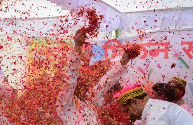 Flower petals and coloured powder is thrown around at an event to celebrate the Hindu festival of Holi for children with cerebral palsy organized by the Trishla Foundation in Allahabad on February 25, 2018. (Photo by Sanjay Kanojia/AFP Photo)