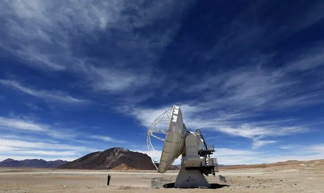 A man takes a photo of a radio antenna that's part of the Atacama Large Milimeter Array Observatory on March 12, 2013 at Llano de Chajnantor, about 43 miles (70 kilometers) from San Pedro de Atacama, Chile. The $1.5 billion ALMA facility, which had its official inauguration on March 13, is considered the world's most expensive ground-based observatory. (Photo by Felipe Trueba/EPA)