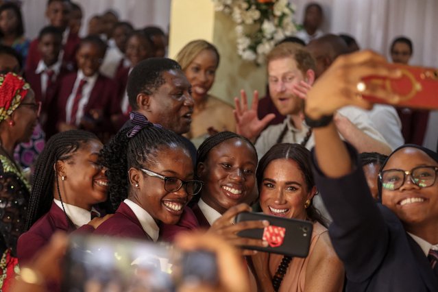 Britain's Meghan, Duchess of Sussex (1st row 2nd R), takes a selfie with students as she arrives with Britain's Prince Harry, Duke of Sussex, during their visit at the Lightway Academy in Abuja on May 10, 2024 as they visit Nigeria as part of celebrations of Invictus Games anniversary. (Photo by Kola Sulaimon/AFP Photo)