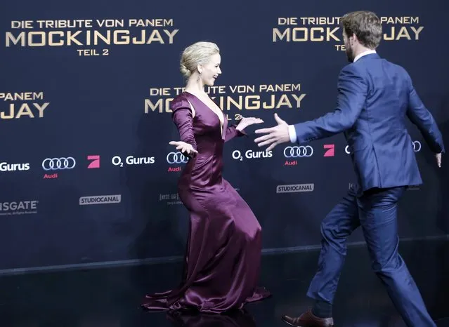 Actor Liam Hemsworth (R) runs to Jennifer Lawrence as they arrive for the world premiere of "The Hunger Games: Mockingjay – Part 2" in Berlin, Germany, November 4, 2015. (Photo by Fabrizio Bensch/Reuters)