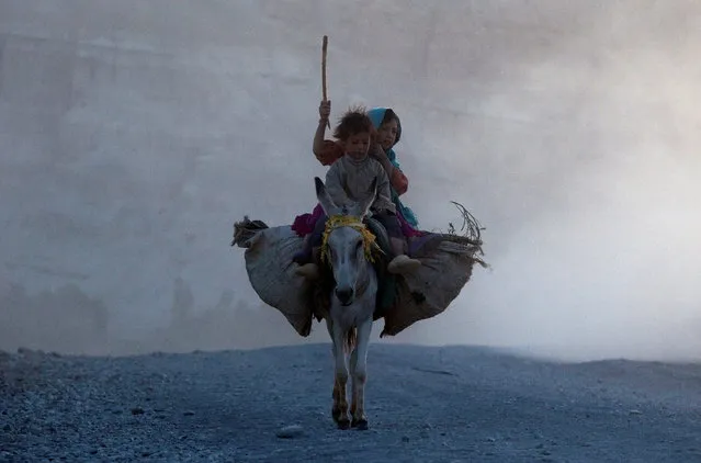 Ethnic Afghan Hazara children return home on a donkey to their village on the outskirts of Bamiyan, located in central Afghanistan August 15, 2009. (Photo by Adrees Latif/Reuters)