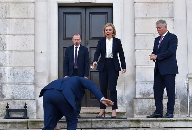 British Foreign Secretary Liz Truss (C), Minister of State for Europe Christopher Heaton-Harris (L) and Secretary of State for Northern Ireland Brandon Lewis (R) react as European Commission vice president Maros Sefcovic slips on an icy step upon his arrival for a meeting at Chevening House in Sevenoaks, south of London, on January 13, 2022. Truss hosted her first face-to-face meeting with Sefcovic, aiming to break months of deadlock over post-Brexit trade in Northern Ireland. (Photo by Ben Stansall/Pool via AFP Photo)