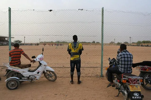 A Liberian man waiting to cross the Sahara watches a football match in Agadez, Niger, May 8, 2016. (Photo by Joe Penney/Reuters)