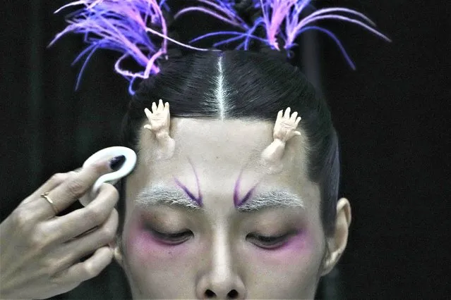 A model for the Dieyingchongchong collections by Chinese designer Dong Yaer has final makeup applied backstage during the China Fashion Week in Beijing, Tuesday, March 28, 2023. (Photo by Andy Wong/AP Photo)