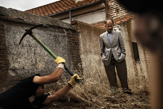 In this photo taken on July 19, 2014, a man looks at an excavation as an A.R.M.H., Association for the Recovery of Historical Memory, volunteer digs on the search for the body of Perfecto de Dios, in a hidden grave in Chaherrero, Spain. Across Spain, volunteer teams of archeologists, anthropologists and forensic scientists head out every year on expeditions to dig for suspected mass graves – a legacy of Spain's fascist past during the time of General Francisco Franco. (Photo by Daniel Ochoa de Olza/AP Photo)