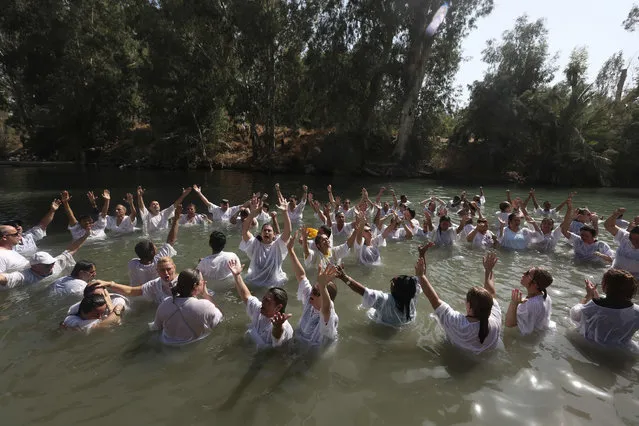 Evangelical Christian pilgrims from Brazil attend a mass baptism ceremony, in the waters of the Jordan River at Yardenit in northern Israel on October 17, 2016. According to the gospel Jesus Christ was baptized in the water of the Jordan River by John the Baptist. Evangelical pilgrims arrived in Israel during the Jewish holiday of Sukkoth or the Feast of Tabernacles to show their support of the Jewish state. (Photo by Menahem Kahana/AFP Photo)