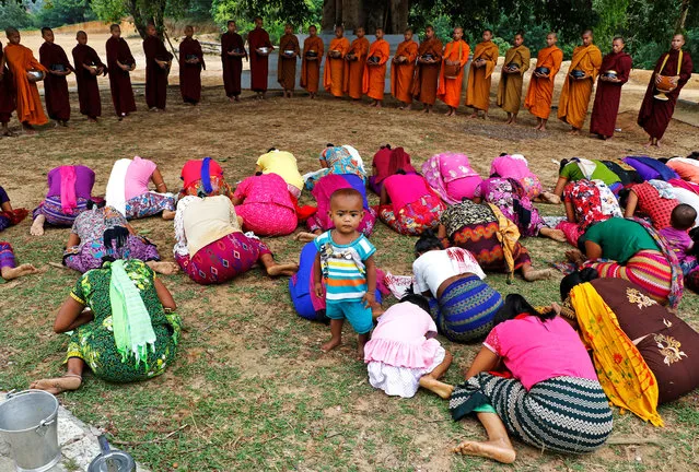 Devotees pray after offering food to the Buddhist monks during celebrations of Buddha Purnima festival, also known as Vesak Day at a temple on the outskirts of Agartala, India April 29, 2018. (Photo by Jayanta Dey/Reuters)