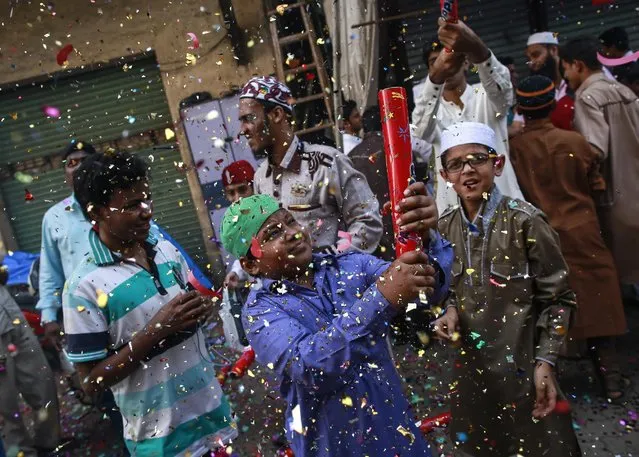 A boy fires confetti poppers as he participates in a procession to mark Eid-e-Milad-ul-Nabi, the birthday celebration of Prophet Mohammad, in Mumbai January 4, 2015. (Photo by Danish Siddiqui/Reuters)