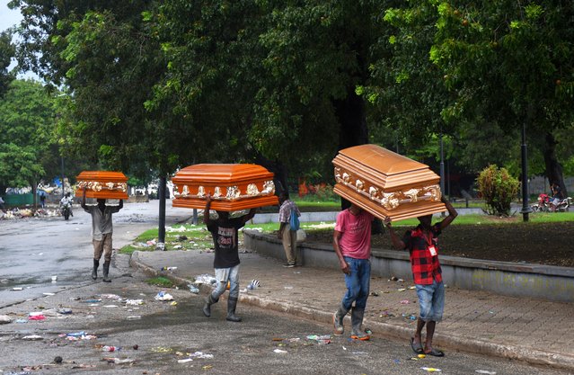 People carry empty coffins after heavy rains caused by the outer bands of Hurricane Melissa flooded some areas, in Port-au-Prince, Haiti, on October 29, 2025. (Photo by Johnson Sabin/Reuters)