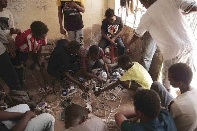 People gather at the home of a volunteer, where they can charge their mobile phones, in Khartoum, Sudan, Thursday, May 25, 2023. The fighting between Sudan’s military and a powerful paramilitary force has displaced more than 1.3 million people, the U.N. migration agency said Wednesday. (Photo by AP Photo)