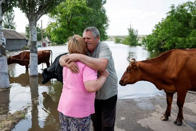 Local residents wait for a barge to evacuate their cows from the village of Afanasiivka, which was partly flooded after the Nova Kakhovka dam breached, amid Russia's attack on Ukraine, in Mykolaiv region, Ukraine on June 9, 2023. (Photo by Alina Smutko/Reuters)