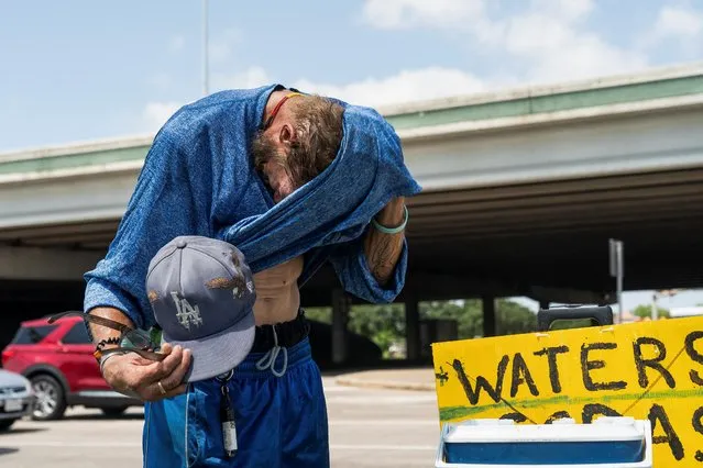 Marc Newman wipes off sweat as he sells cold water to drivers during hot weather in Houston, Texas, U.S. June 28, 2023. (Photo by Go Nakamura/Reuters)