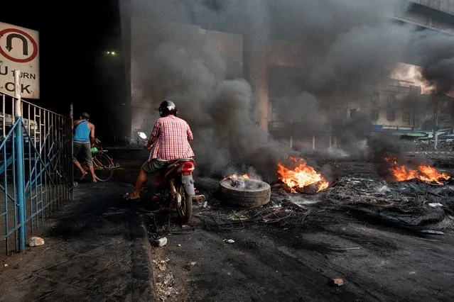 Smoke billows from burning tyres set alight to create smoke cover during a crackdown at Bayint Naung Junction in Yangon, Myanmar on March 16, 2021, in this photograph obtained by Reuters. (Photo by Reuters/Stringer)