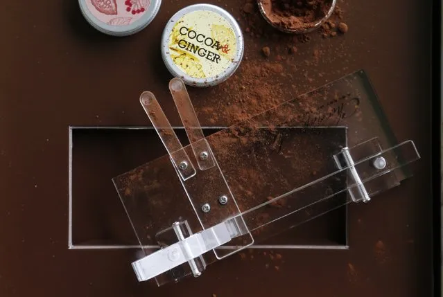 A Chocolate Shooter is displayed near cocoa powder in the factory of Belgian chocolatier Dominique Persoone in Bruges, February 3, 2015. (Photo by Francois Lenoir/Reuters)