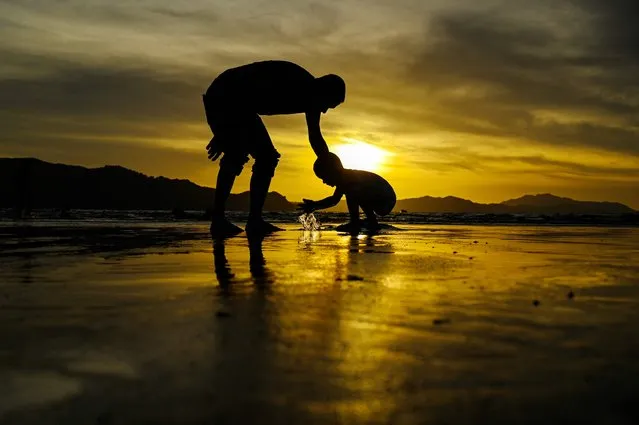 People play on a beach at sunset in Banda Aceh on July 4, 2023. (Photo by Chaideer Mahyuddin/AFP Photo)