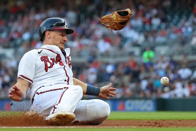 Sean Murphy #12 of the Atlanta Braves slides safely into third base after colliding with Ryan McMahon #24 of the Colorado Rockies and knocking his glove off on a single by Matt Olson #28 in the second inning at Truist Park on June 15, 2023 in Atlanta, Georgia. (Photo by Kevin C. Cox/Getty Images)