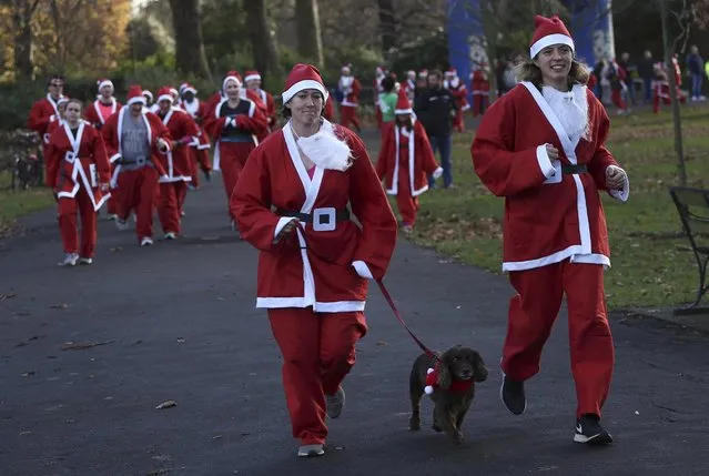 Participants with their dog take part in a Santa Run at Battersea Park in London, Britain December 3, 2016. (Photo by Neil Hall/Reuters)