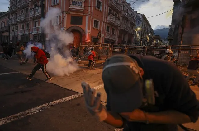 Demonstrators clash with police officers during a protest against the Government of Guillermo Lasso, in Quito, Ecuador, 15 June 2022. The national strike called by the indigenous movement against the economic policy of the Government of conservative Guillermo Lasso continued with a street agenda. A large march of students walked through several streets in the center of the Ecuadorian capital and was later dispersed by the police using tear gas in a square. (Photo by Jose Jacome/EPA/EFE)